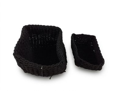 une paire de paniers tressés noirs posés sur une surface blanche, sur fond blanc