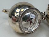 two silver teapots sitting next to each other on a table