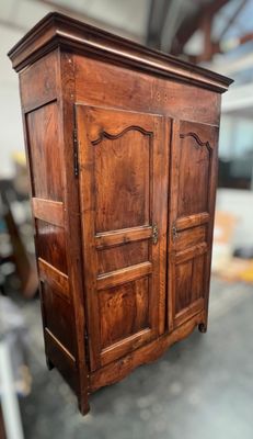 a wooden armoire in the middle of a room