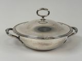 an antique silver plated casserole with a lid and handles