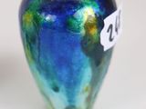 a blue and green vase sitting on a white surface