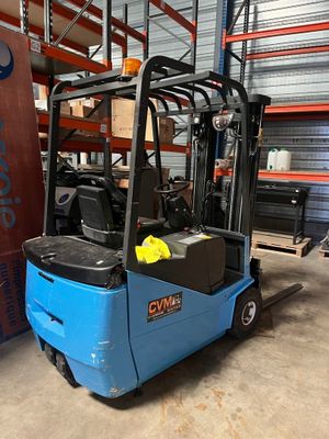 un chariot élévateur bleu garé dans un entrepôt