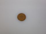a close up of a penny sitting on top of a white surface