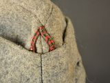 a close up of a jacket with a red triangle in the pocket