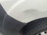 a white van with a black rim parked in a parking lot