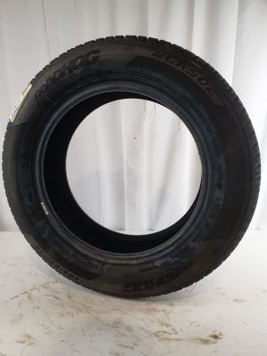 a close up of a tire on a white surface with a white curtain in the background