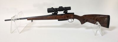 le fusil est posé sur un support transparent équipé d'une lunette de visée