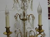a small crystal chandelier with three candles on it
