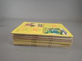 several children ' s books stacked on top of each other on a table