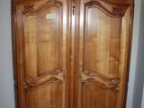 a large wooden armoire in the corner of a room