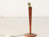 une lampe posée sur un socle en bois et munie d'un cordon