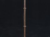 an old iron candle holder with a candle on top