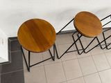 three wooden stools sitting next to each other on a tiled floor