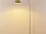 Le lampadaire est posé sur le parquet de la pièce.