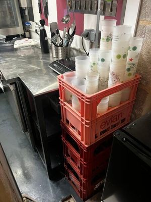 une pile de gobelets en plastique posée sur une caisse rouge
