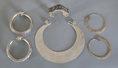 plusieurs bagues en argent et un collier en argent posés sur une table