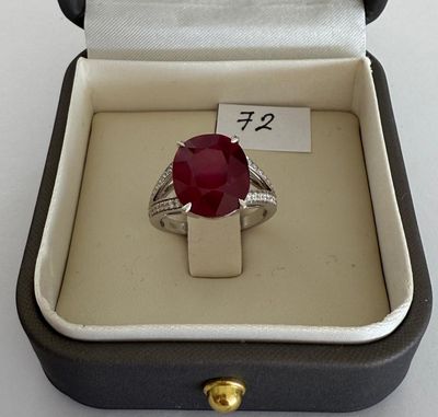 a ring in a box that has a red stone in it