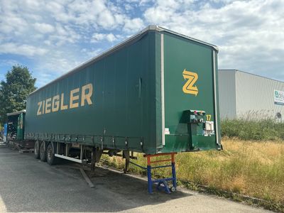 une semi-remorque verte garée sur le bord de la route