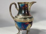 a silver vase with a blue and red design on it