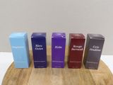 four boxes of blue, purple, and black perfume sitting on a wooden board