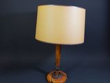 a wooden table lamp with a beige shade on a black background