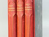 trois livres rouges dans une boîte posée sur une surface blanche
