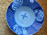 a blue and white plate on a table with a tag