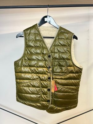 Le gilet est vert et porte une étiquette rouge.