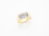an 18k yellow gold ring set with a baguet cut diamond