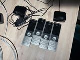 four cell phones sitting on a table next to a charger