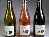 trois bouteilles de vin posées l'une à côté de l'autre sur une table