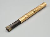 un stylo noir et doré posé sur une table blanche