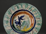 une assiette bleue et verte sur laquelle est représenté un homme à cheval