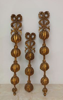 three gold metal candlesticks sitting on top of a marble counter