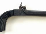 un vieux pistolet avec une poignée en bois sur une surface blanche