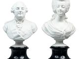 pair of white busts of women on black bases on a white background