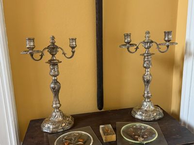 deux bougies en argent posées sur une table dans une pièce