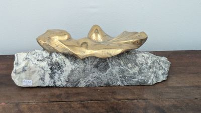 a gold leaf on a rock on a wooden table