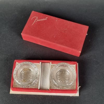 une paire de dessous de verre plaqués argent dans une boîte rouge