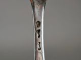 a silver spoon with a face on it on a table
