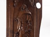 an antique carved wood plaque depicting a man with a dog