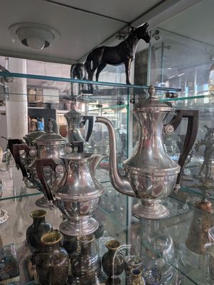 many silver vases on display in a glass case