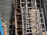 de nombreuses échelles empilées dans un entrepôt