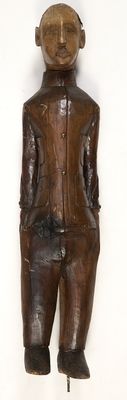 une statue en bois représentant un homme coiffé d'un chapeau