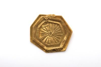 une image représentant une assiette en or ornée d'un motif floral