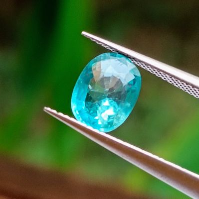 a close up of a blue diamond being held by a pair of pliers