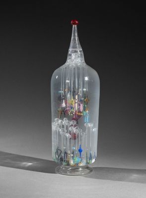 a glass bottle with a lot of small glass objects inside of it