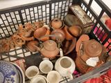 a basket full of pots and cups sitting on a table