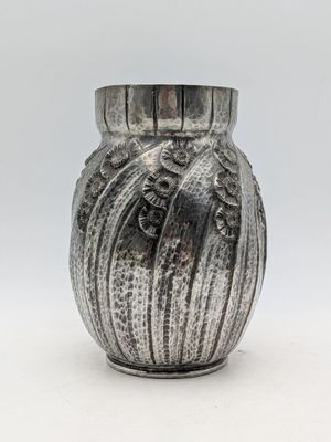 un vase en argent posé sur une table