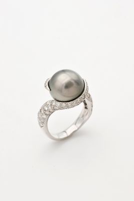 une bague en perle noire et diamants sur fond blanc